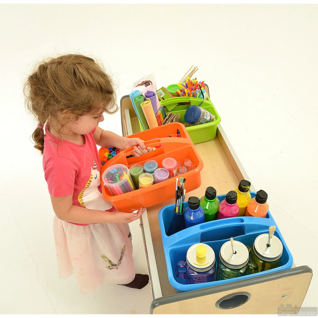 Child using art trolley filled with art supplies including paint, paint brushes, chalk and felt mats in different colours
